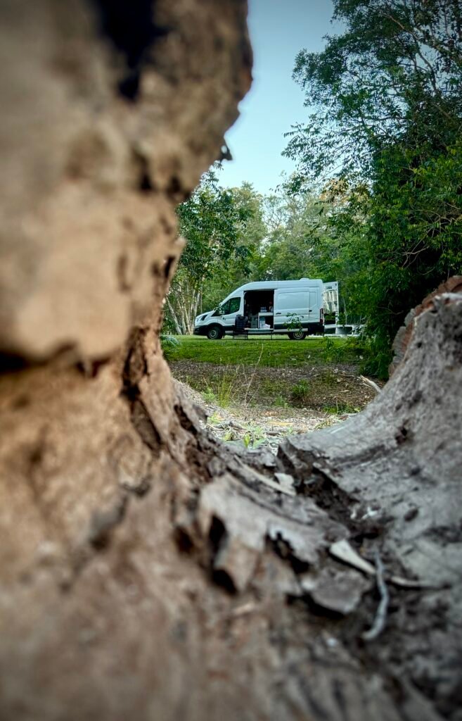 Vanlife van in Australian bush setting with old fallen tree trunk